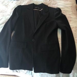 Multiple women’s suit jackets, one full suit.
